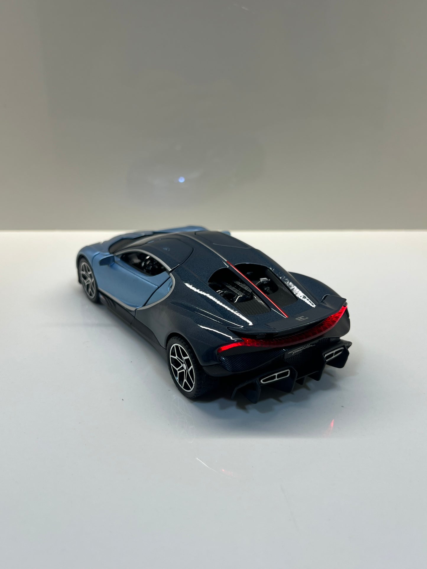 Maqueta a escala Bugatti Tourbillon azul vista trasera sobre fondo blanco